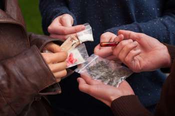 Różne rodzaje narkotyków w dłoniach handlarzy