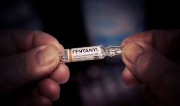 Fentanyl w fiolce do iniekcji trzymany przez mężczyznę